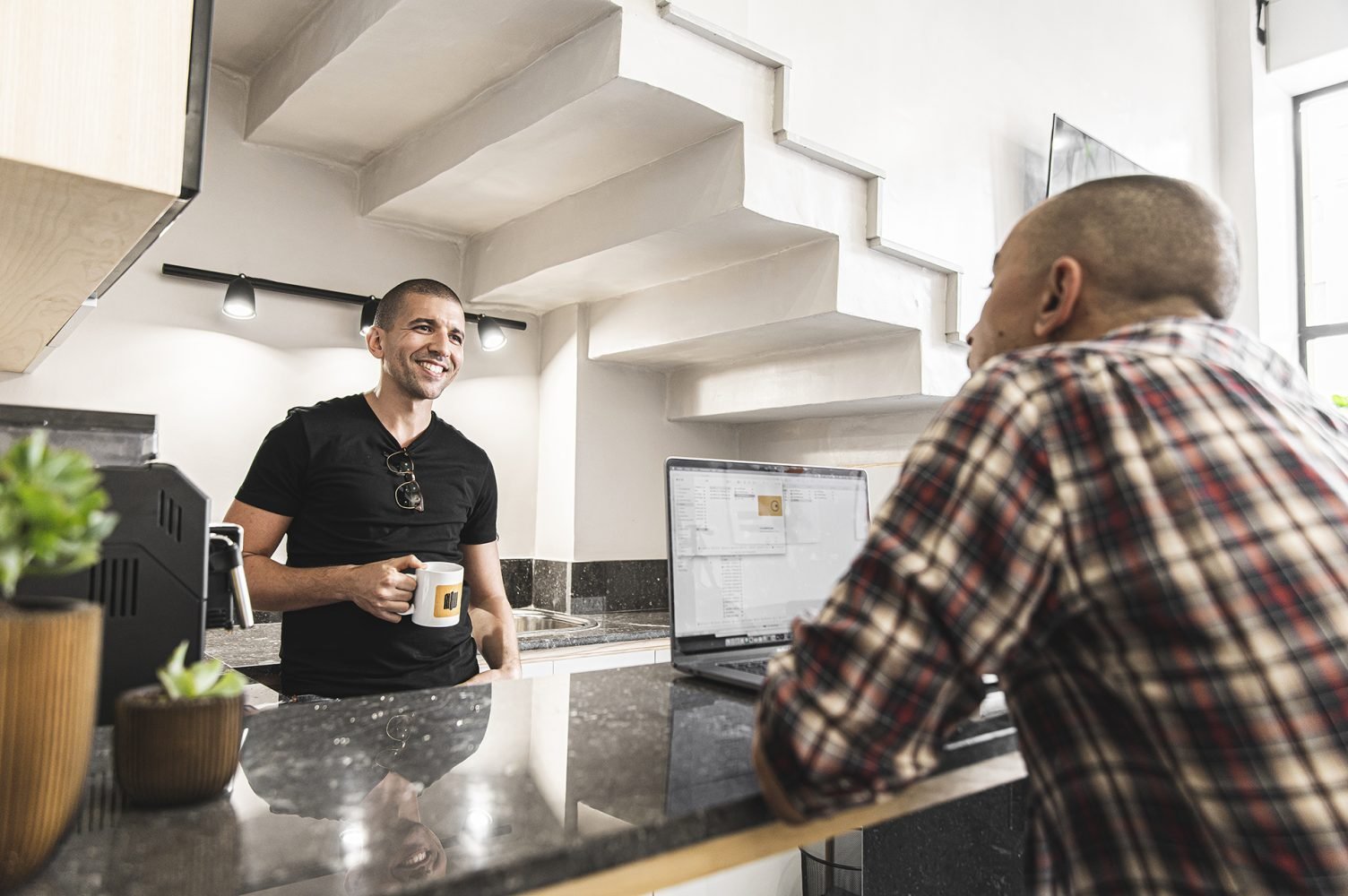 Échange convivial entre professionnels dans la kitchenette de Mow, espace coworking à Casablanca, favorisant la collaboration et la convivialité