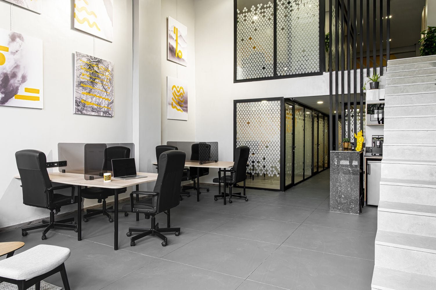 Espace de travail collaboratif chez Mow, coworking à Casablanca, avec bureaux partagés, décoration murale moderne, et espace multifonctionnel pour un environnement de travail inspirant
