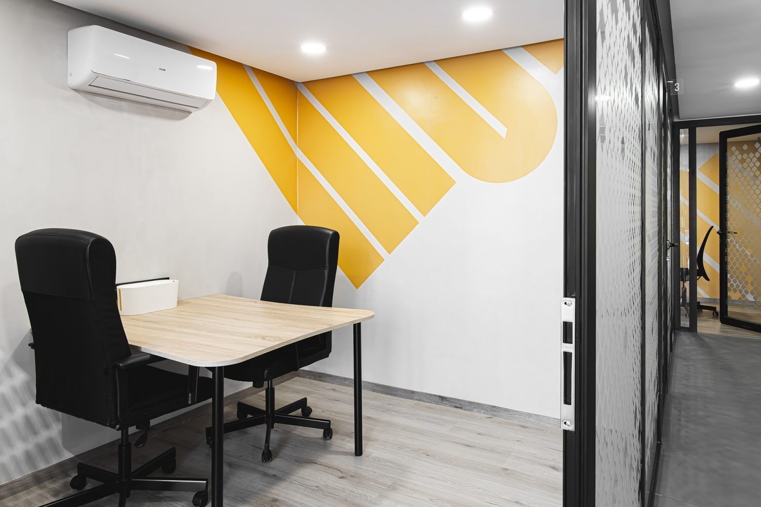 Bureau privé lumineux chez Mow, espace coworking à Casablanca, avec un design mural moderne et des sièges ergonomiques pour un espace de travail efficace