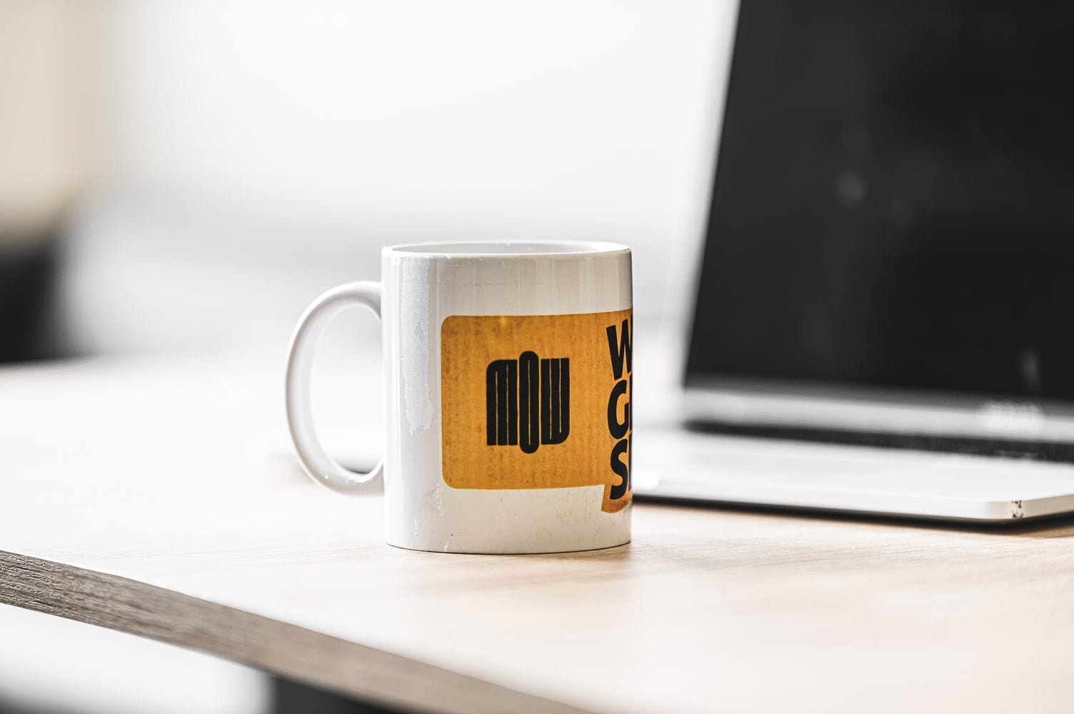 Tasse personnalisée avec le logo de Mow sur un bureau moderne, représentant l'identité de l'espace coworking à Casablanca, alliant style et fonctionnalité