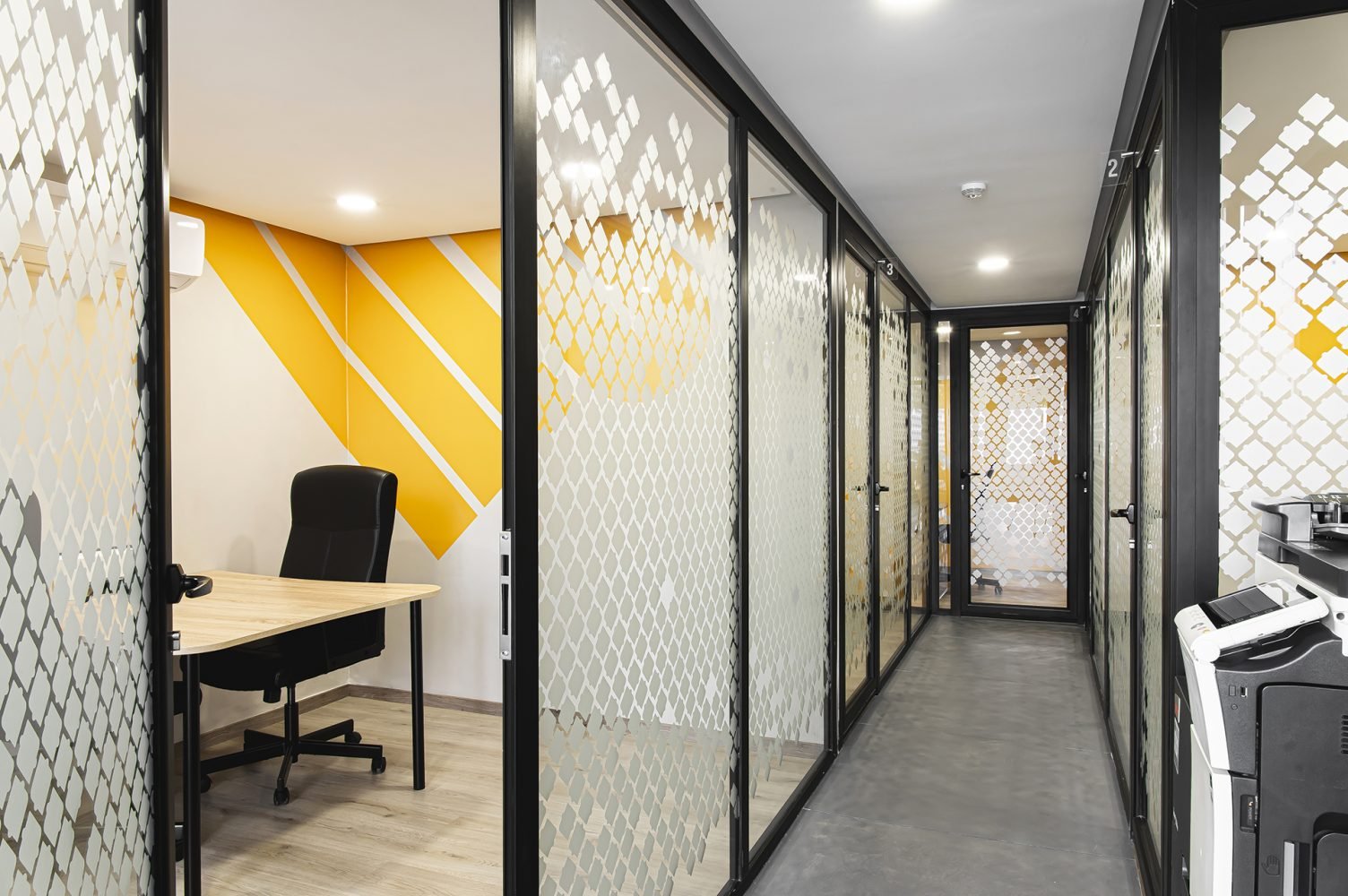 Couloir avec bureaux privés vitrés chez Mow, espace coworking à Casablanca, offrant des espaces de travail modernes et isolés pour les professionnels