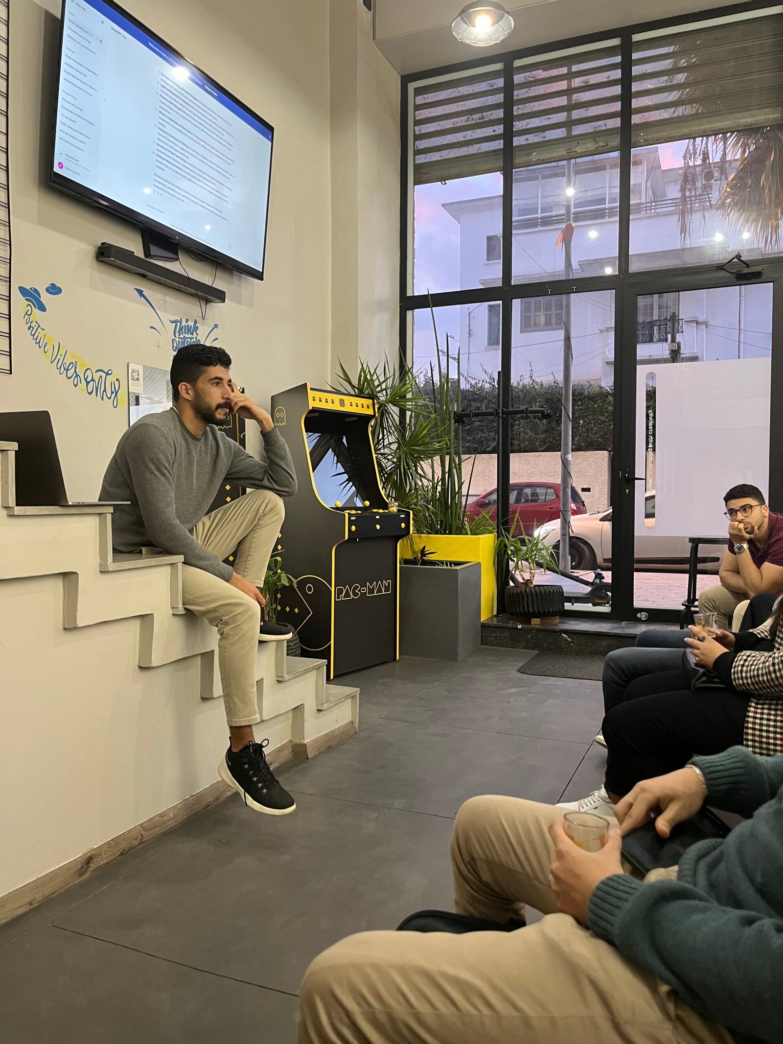 Un employé de Mow présentant des idées sur un écran géant devant un groupe de collègues assis dans un espace de travail créatif et décontracté