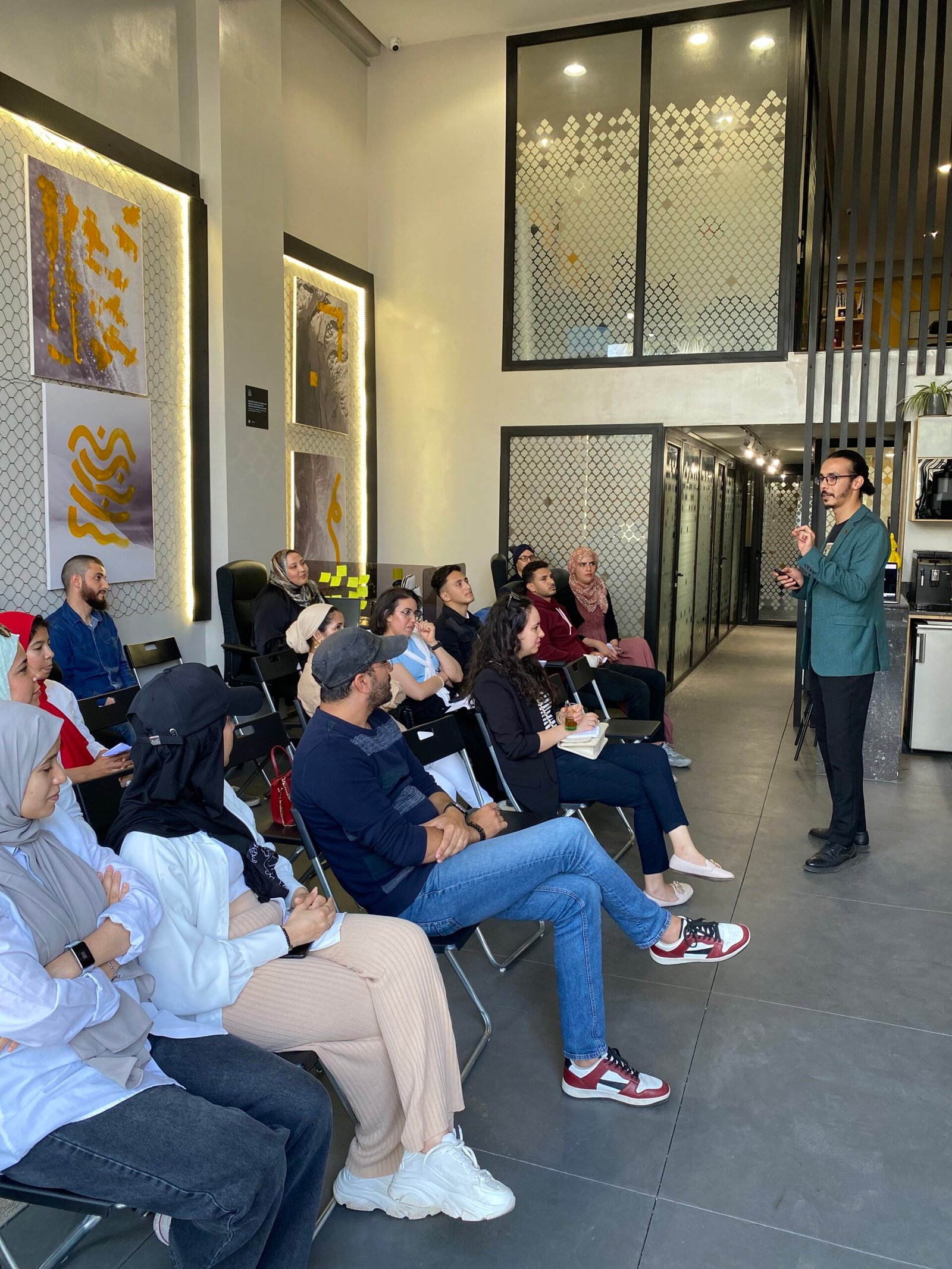 Groupe de professionnels de Mow participant à une session de formation avec un intervenant, dans un espace de bureau moderne