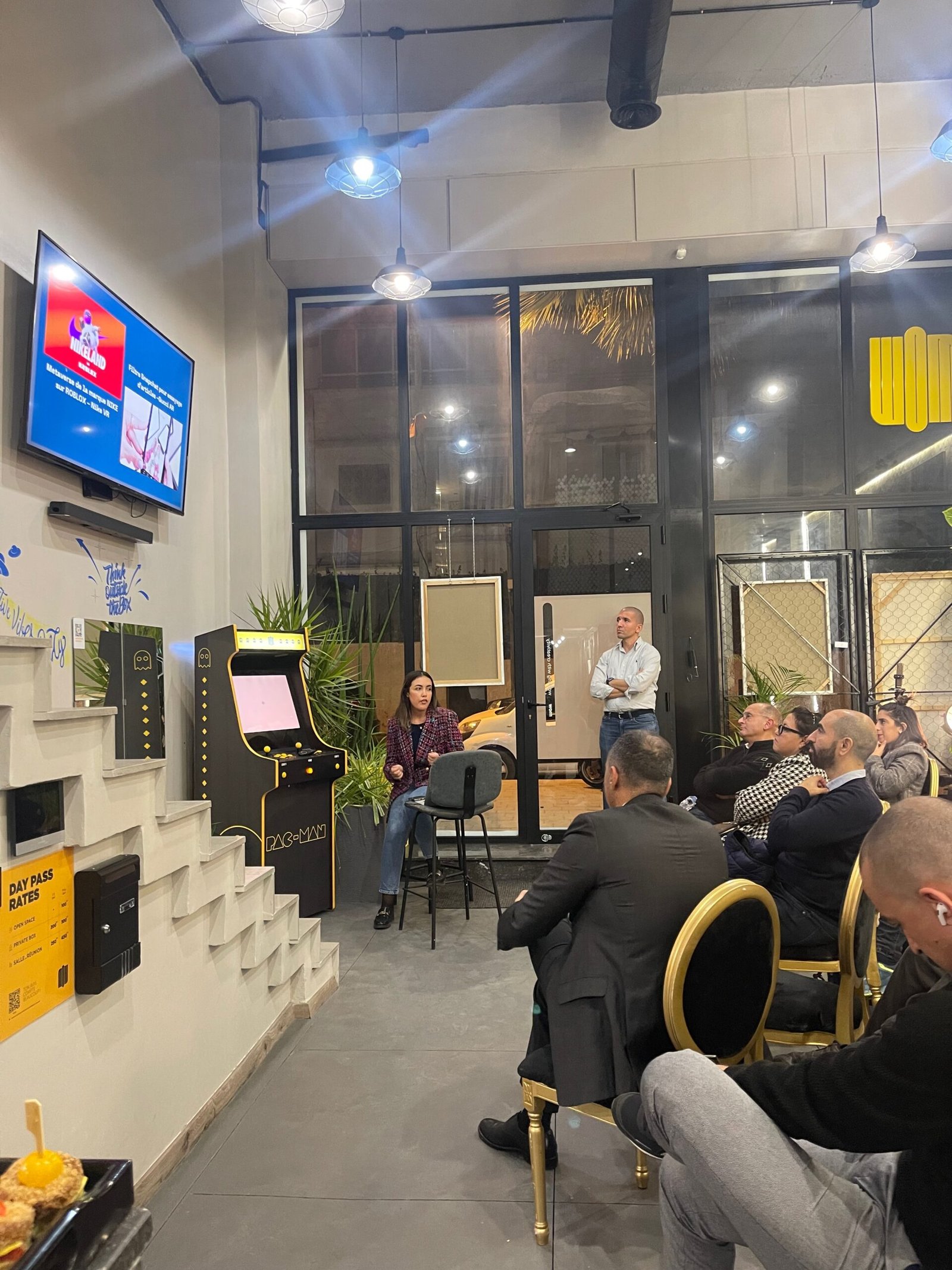 Présentation interactive avec un orateur principal et une audience engagée dans un espace de bureau moderne chez Mow