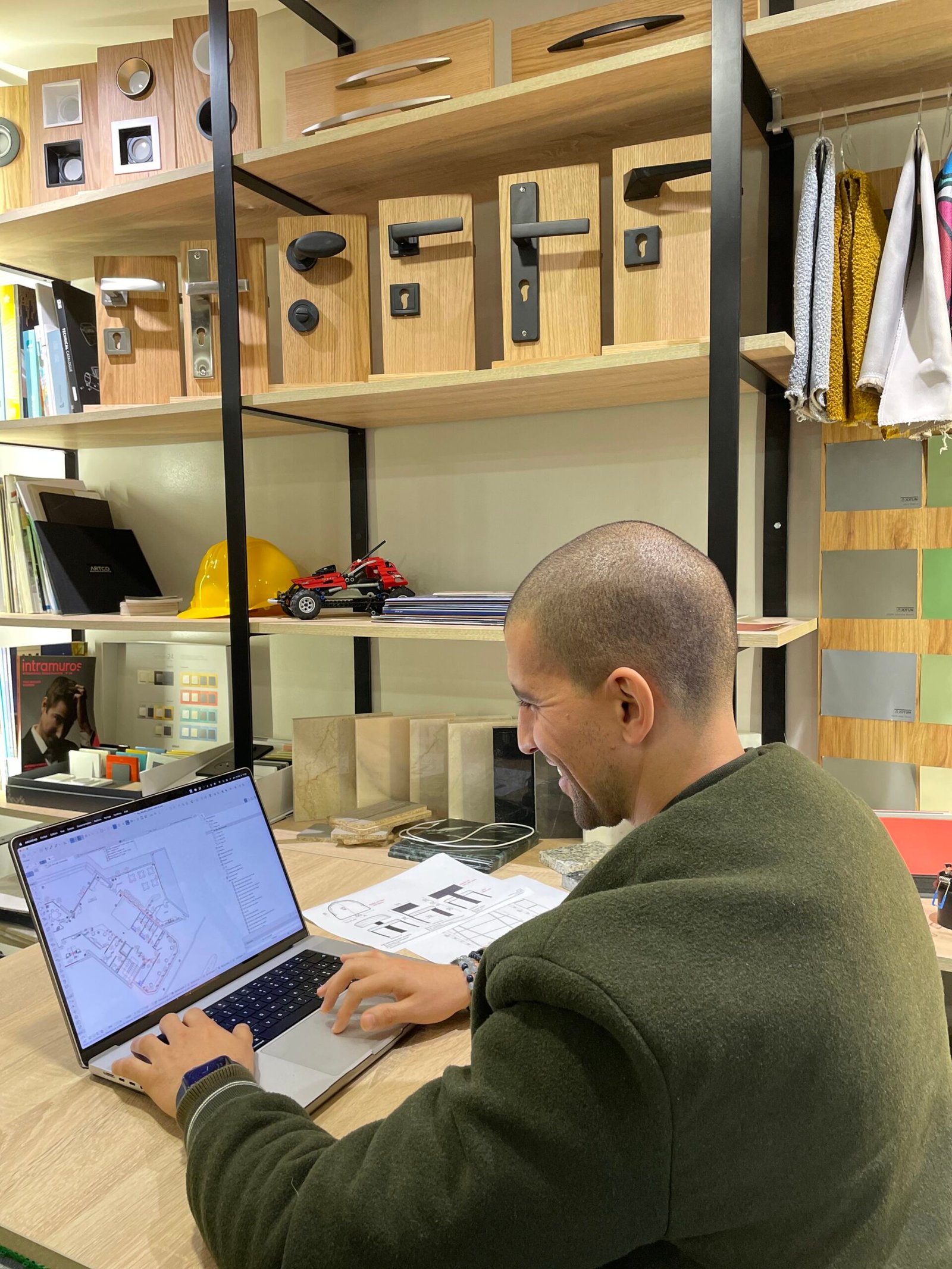 Employé de Mow concentré sur la conception de plans architecturaux sur son ordinateur portable dans un espace de travail créatif et moderne