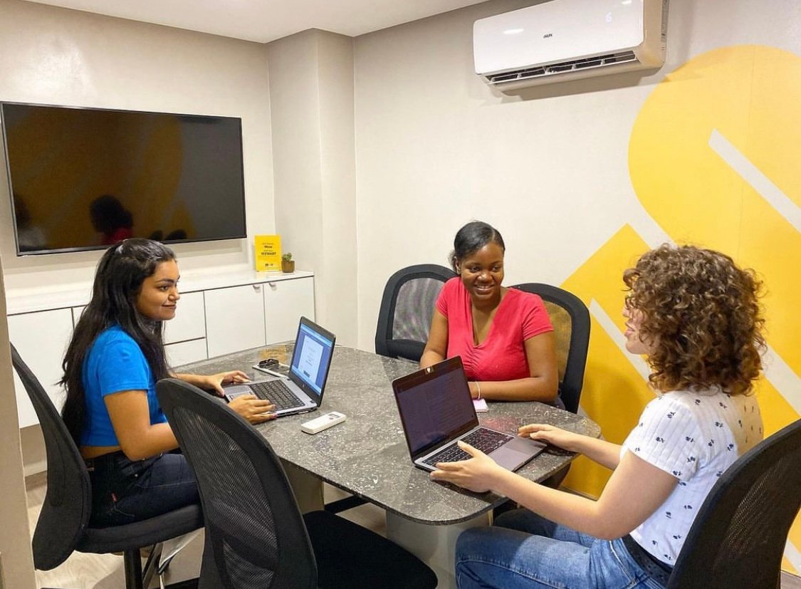 Trois professionnels collaborant sur des projets avec des ordinateurs portables dans un bureau moderne chez Mow