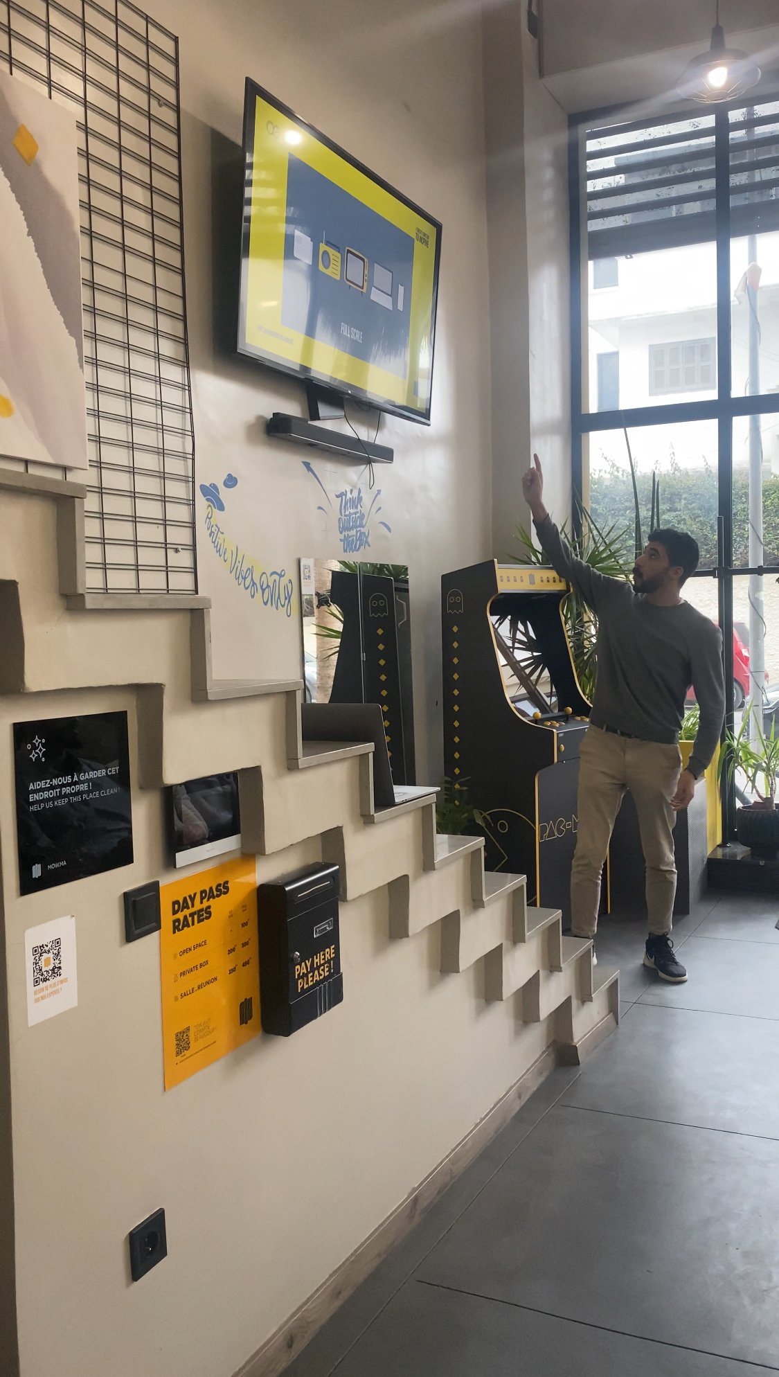 Un invité de Mow interagissant avec un écran numérique dans un espace d'accueil moderne