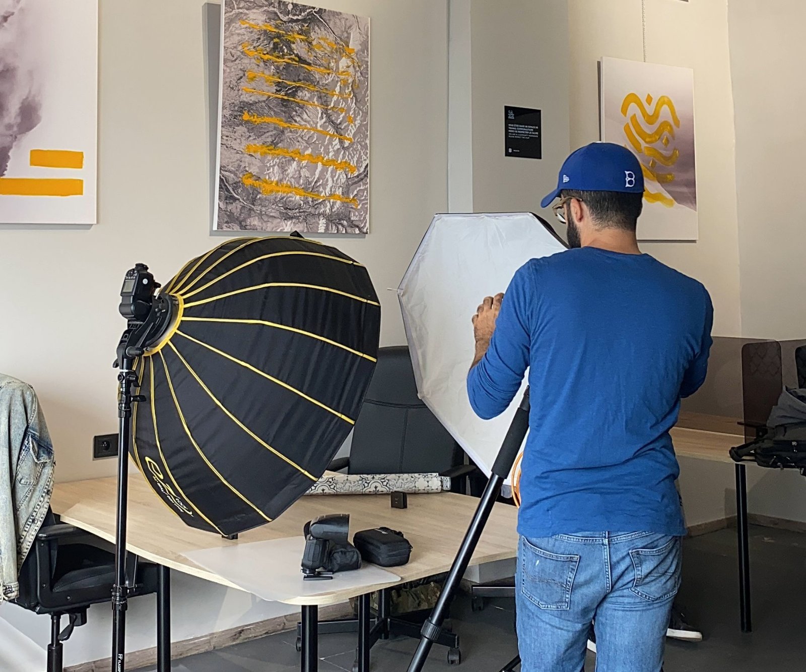 Photographe professionnel préparant une séance photo de produit dans un espace de coworking créatif et inspirant chez Mow à Casablanca, mettant en valeur la collaboration et l'innovation