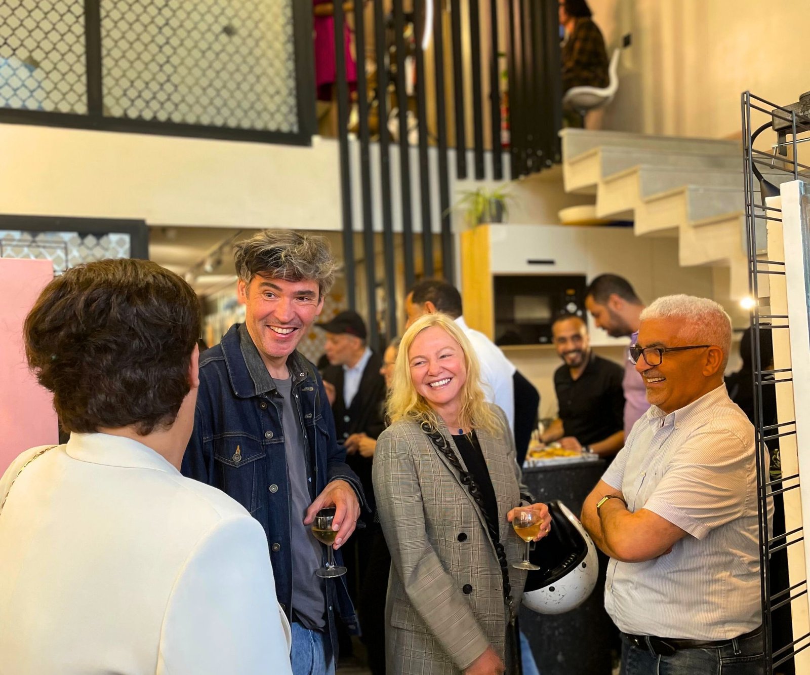 Groupe de personnes partageant un moment convivial lors d'un événement au coworking MOW à Casablanca, souriants et en pleine conversation.