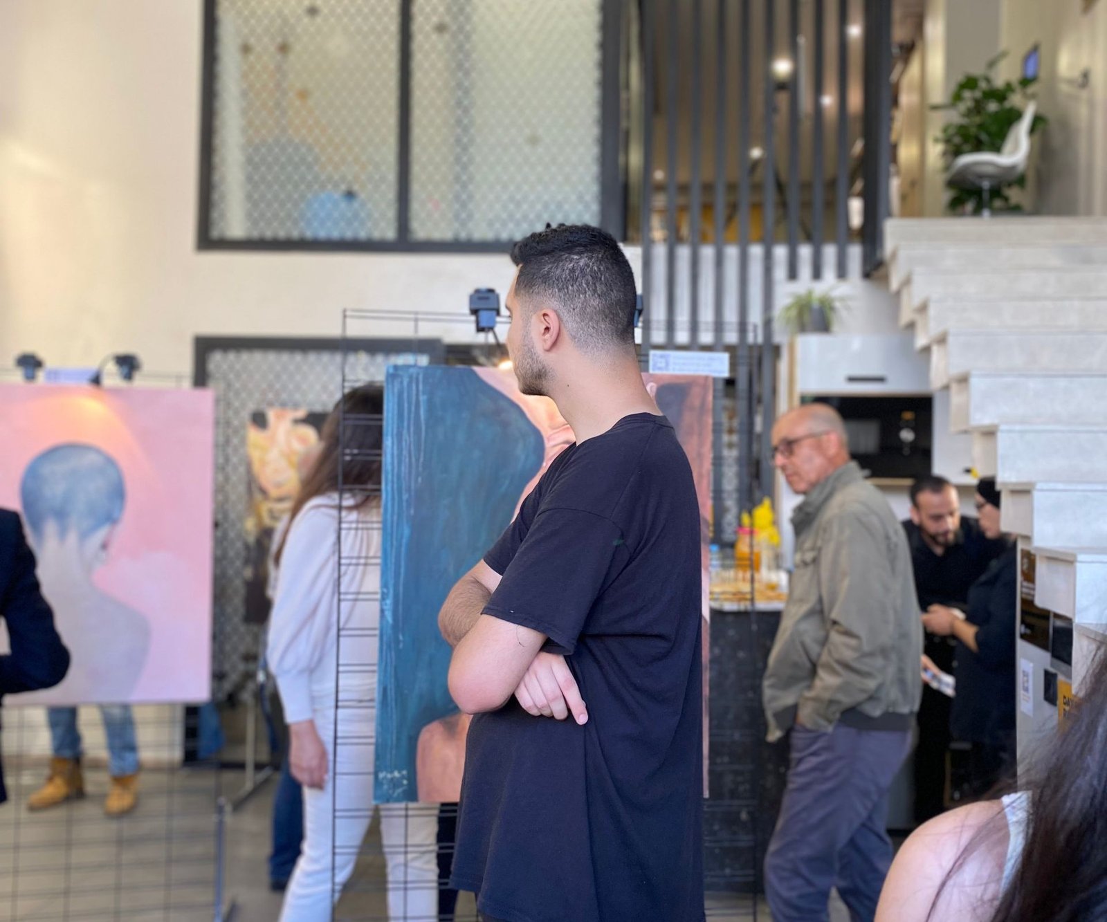 Participant observant des œuvres d'art lors d'un événement de networking chez Mow à Casablanca, favorisant les échanges créatifs et professionnels