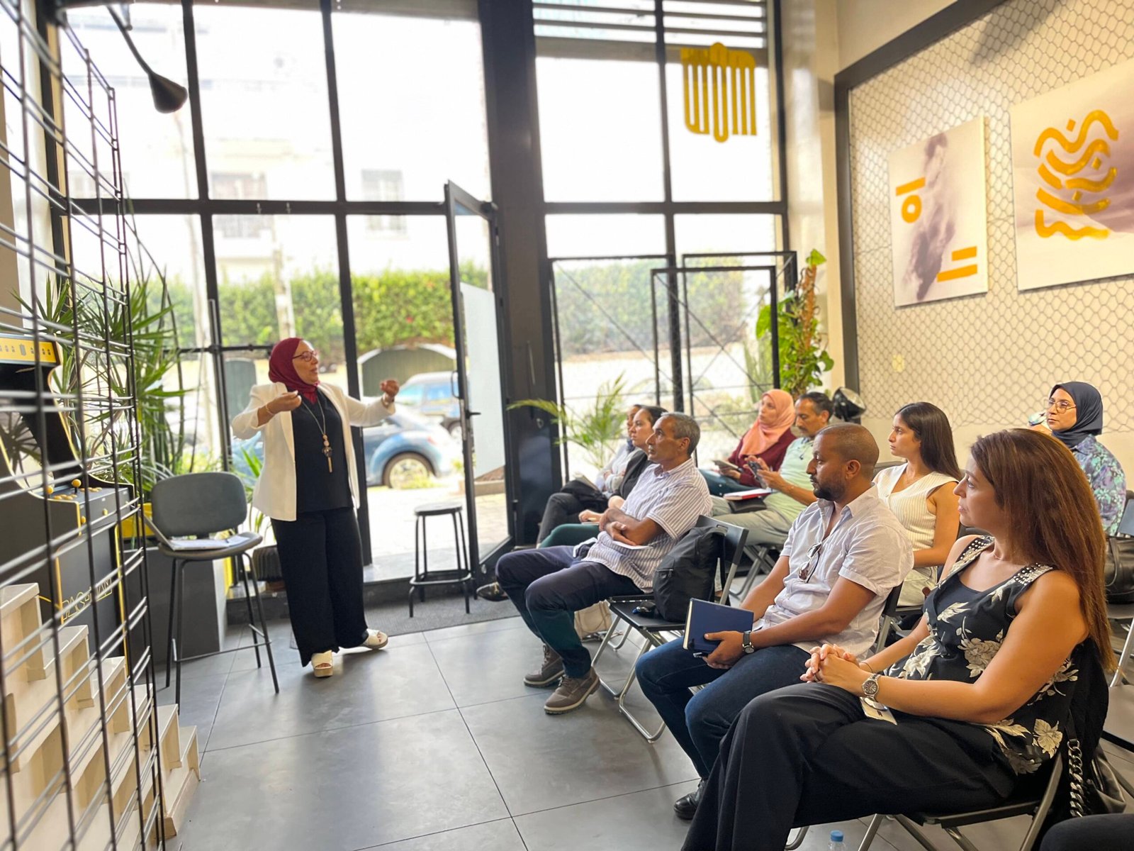 Animatrice engageant le public lors d'un événement au coworking MOW à Casablanca, entourée de participants attentifs.