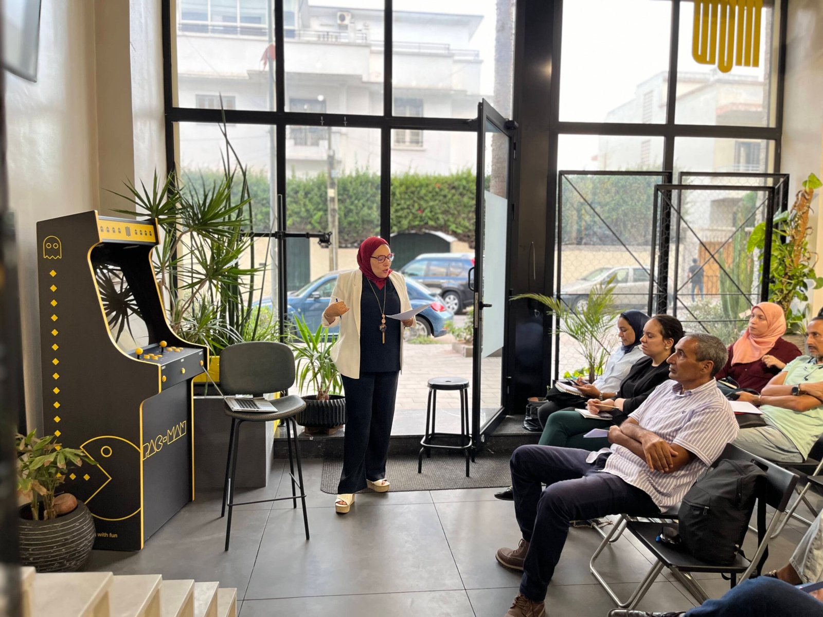 Animatrice engageant le public lors d'un événement au coworking MOW à Casablanca, entourée de participants attentifs.