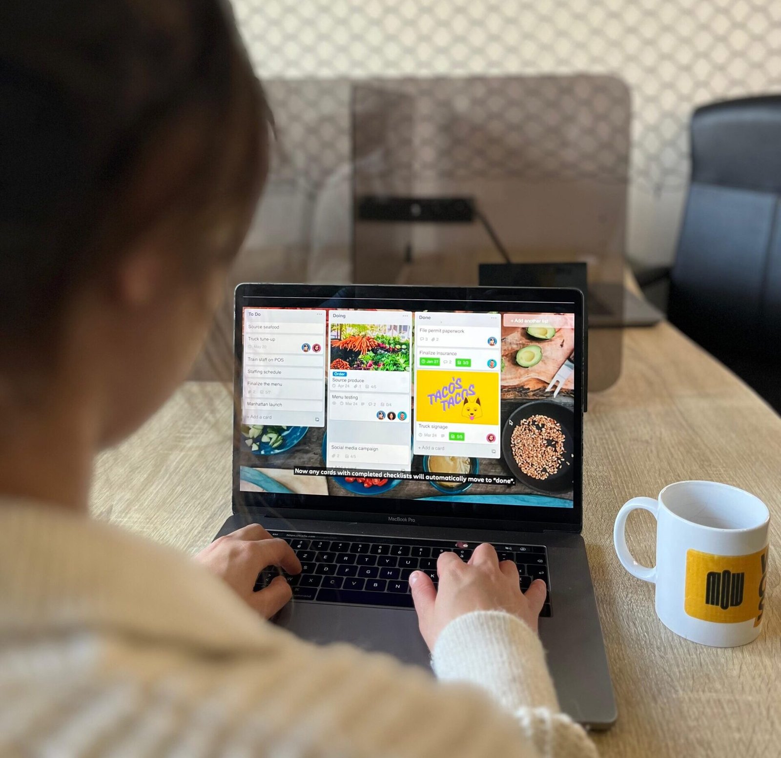 Tableau Trello affiché sur un ordinateur portable dans un espace de coworking.